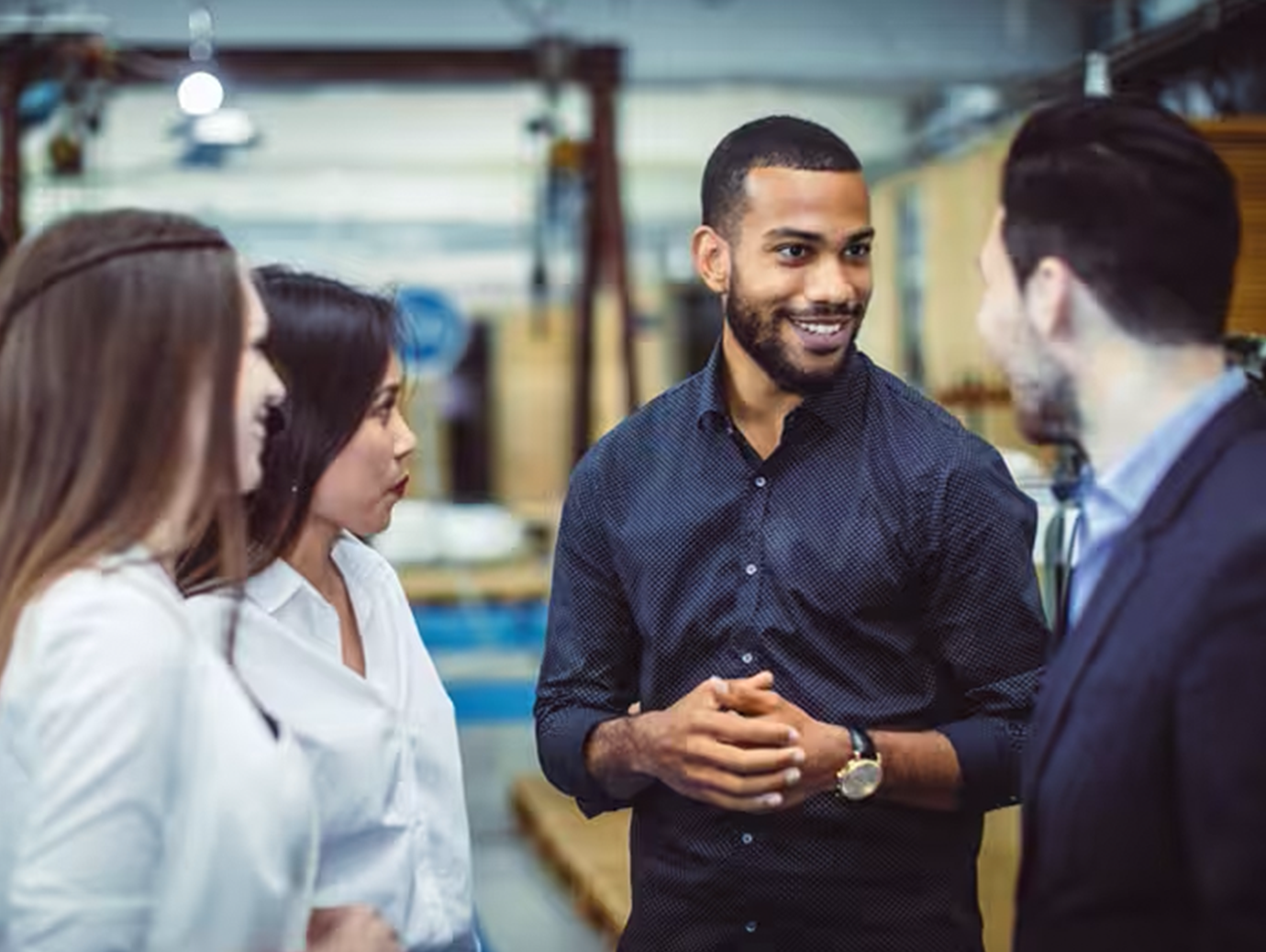 Four people in discussion in a factory