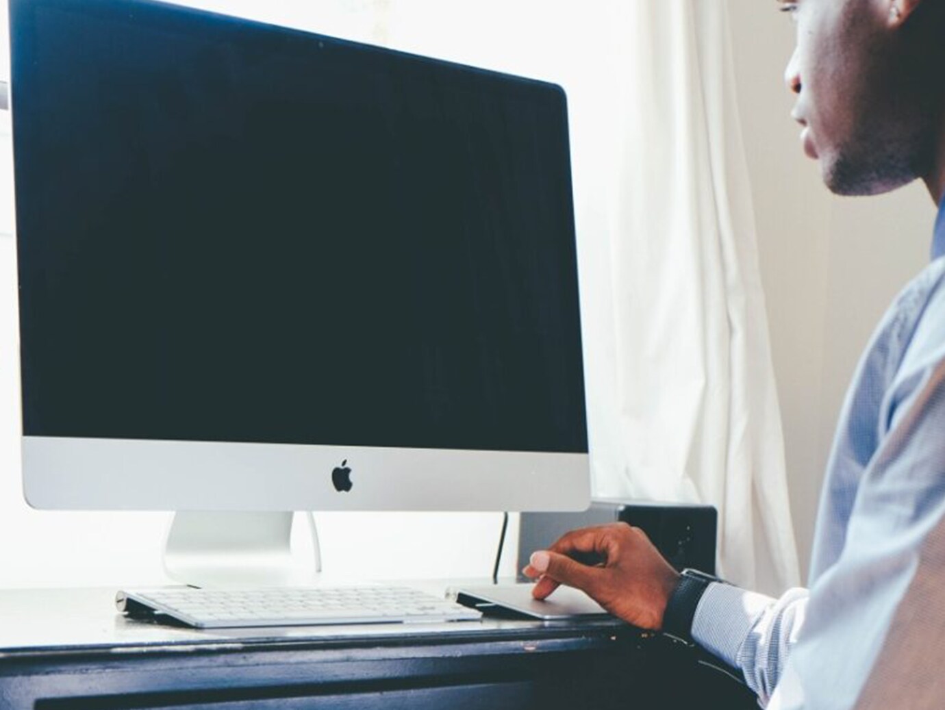 A man looking at a desktop screen