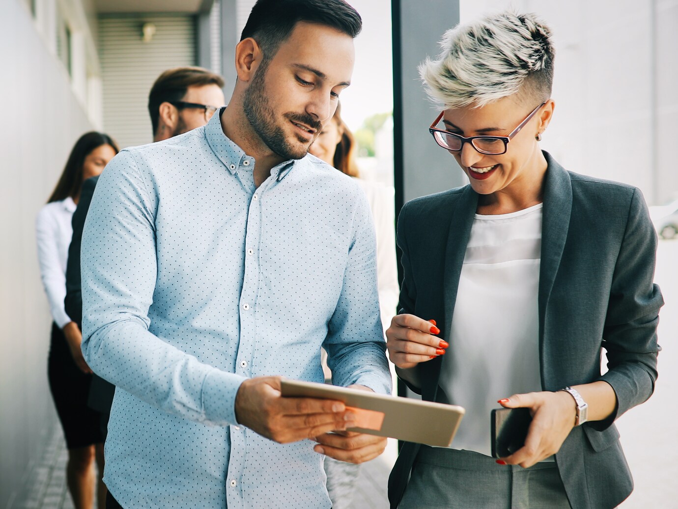 Two colleagues in discussion looking at a tablet PC