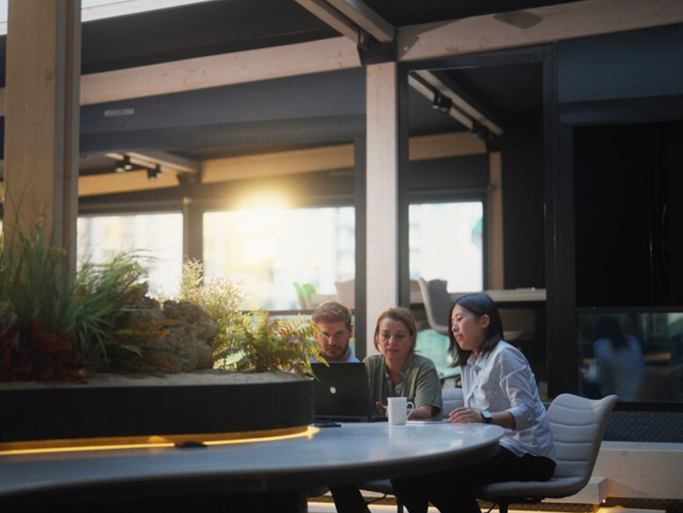 Three colleagues having a conversation at a cafeteria