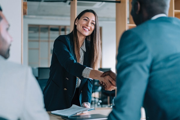 A lady employee shaking hand with her co employee