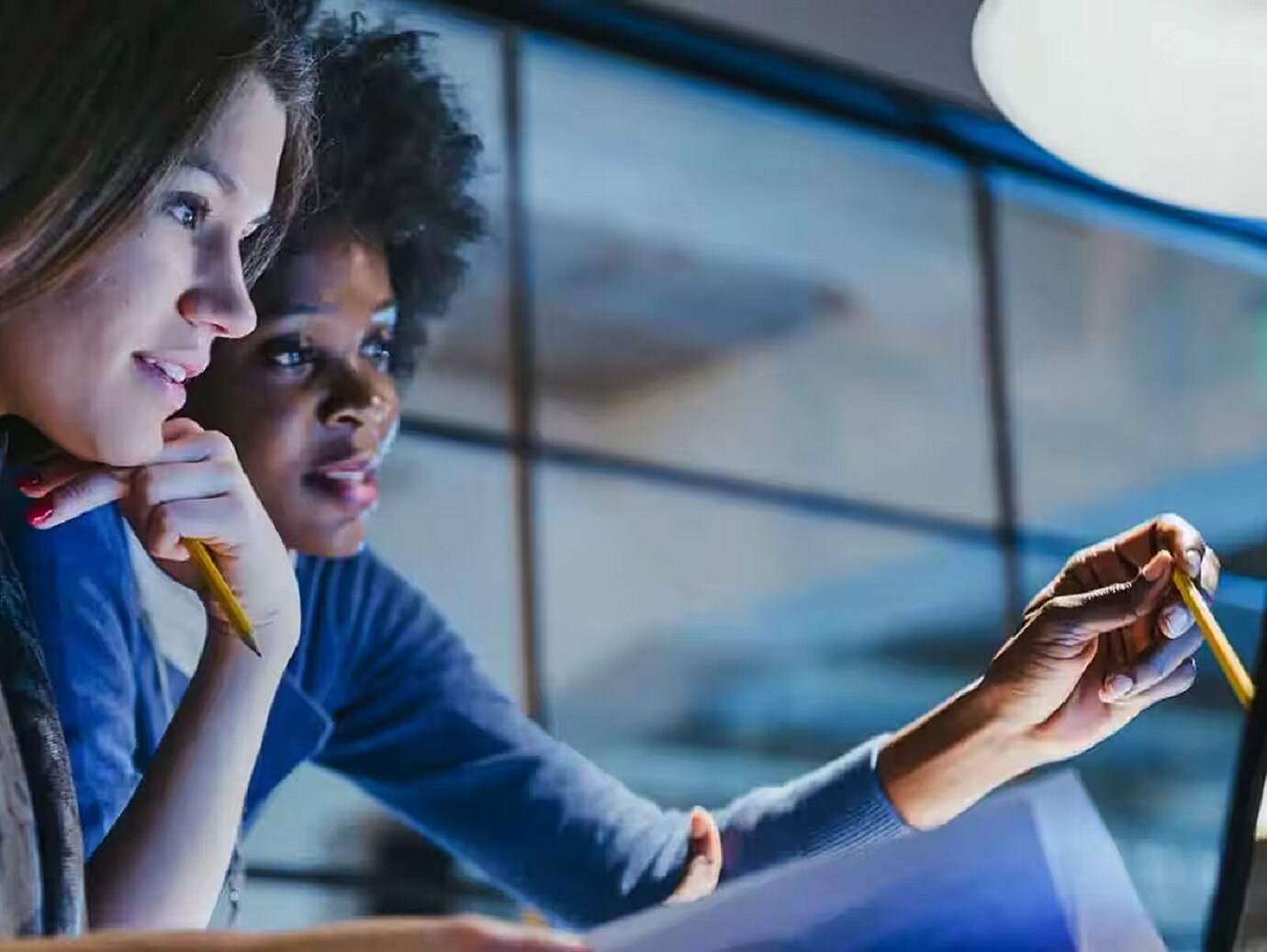 A colleague explaining the other pointing at a monitor