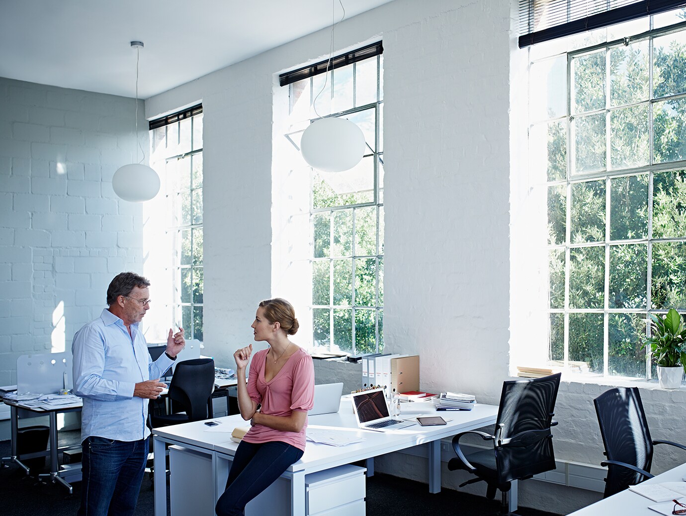 A male and female colleague conversing in a modern office