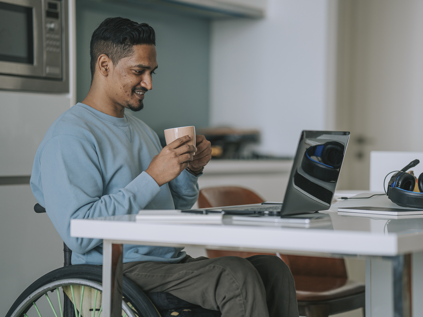 Man in wheelchair looking at the laptop