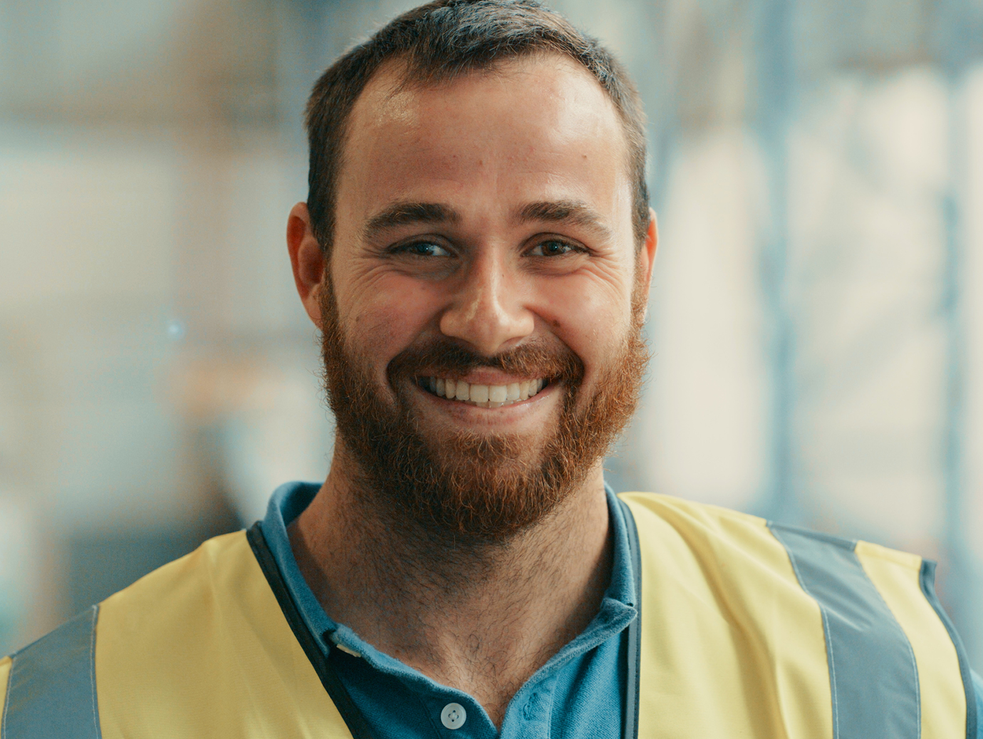 A man in a safety vest smiling at the camera